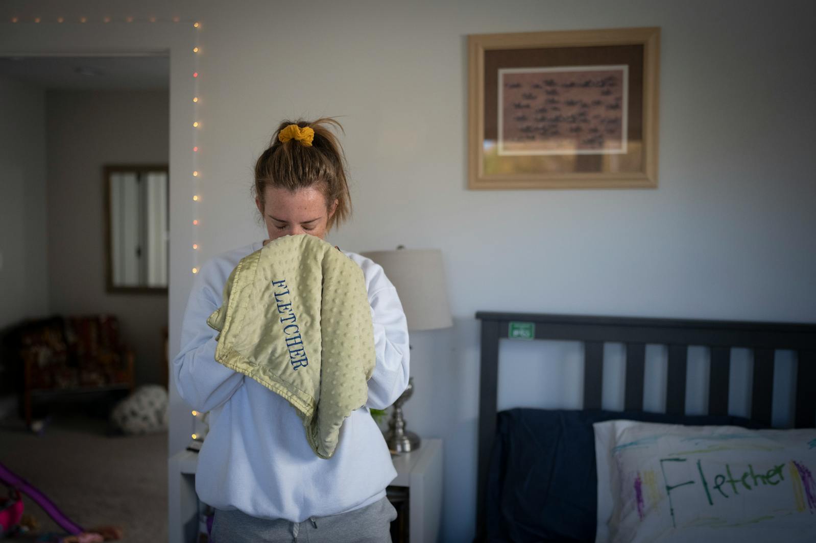 Mollie Merkel breathes in the scent of her son Fletcher on a blanket he slept with in his bedroom at their home in Minneapolis.