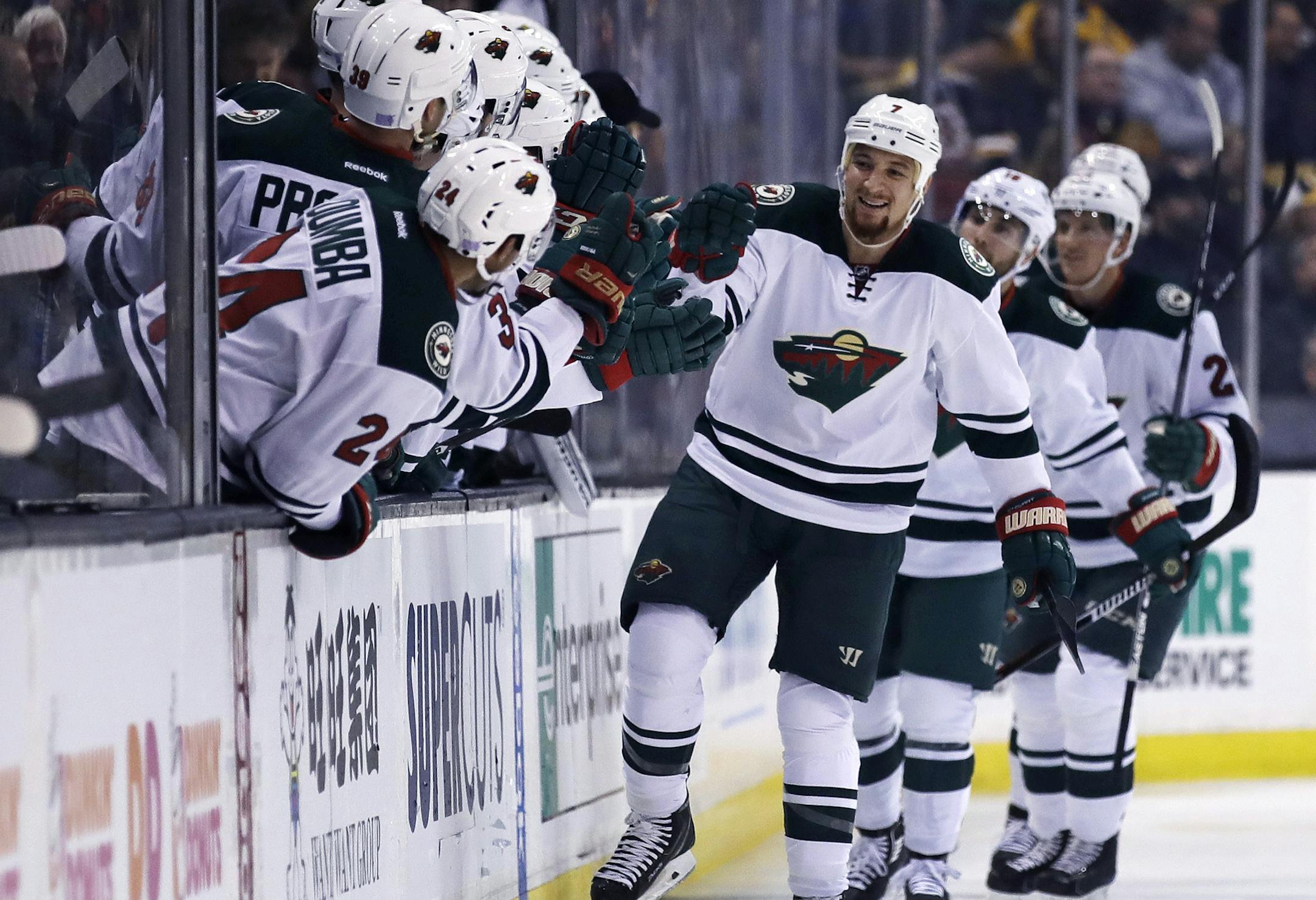 Minnesota Wild right wing Chris Stewart, center, is congratulated by teammates after his goal against Boston Bruins goalie Malcolm Subban during the second period of an NHL hockey game in Boston, Tuesday, Oct. 25, 2016. (AP Photo/Charles Krupa)