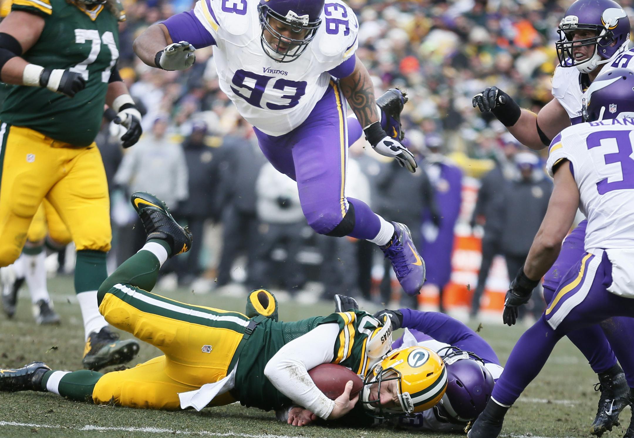 Packers quarterback Matt Flynn was tackled by Vikings strong safety Jamarca Sanford (33) in the third quarter as Kevin Williams dove over them Sunday.