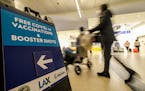 A sign advertising free COVID-19 vaccine shots was posted at the Los Angeles International Airport on Dec. 22, 2021. 