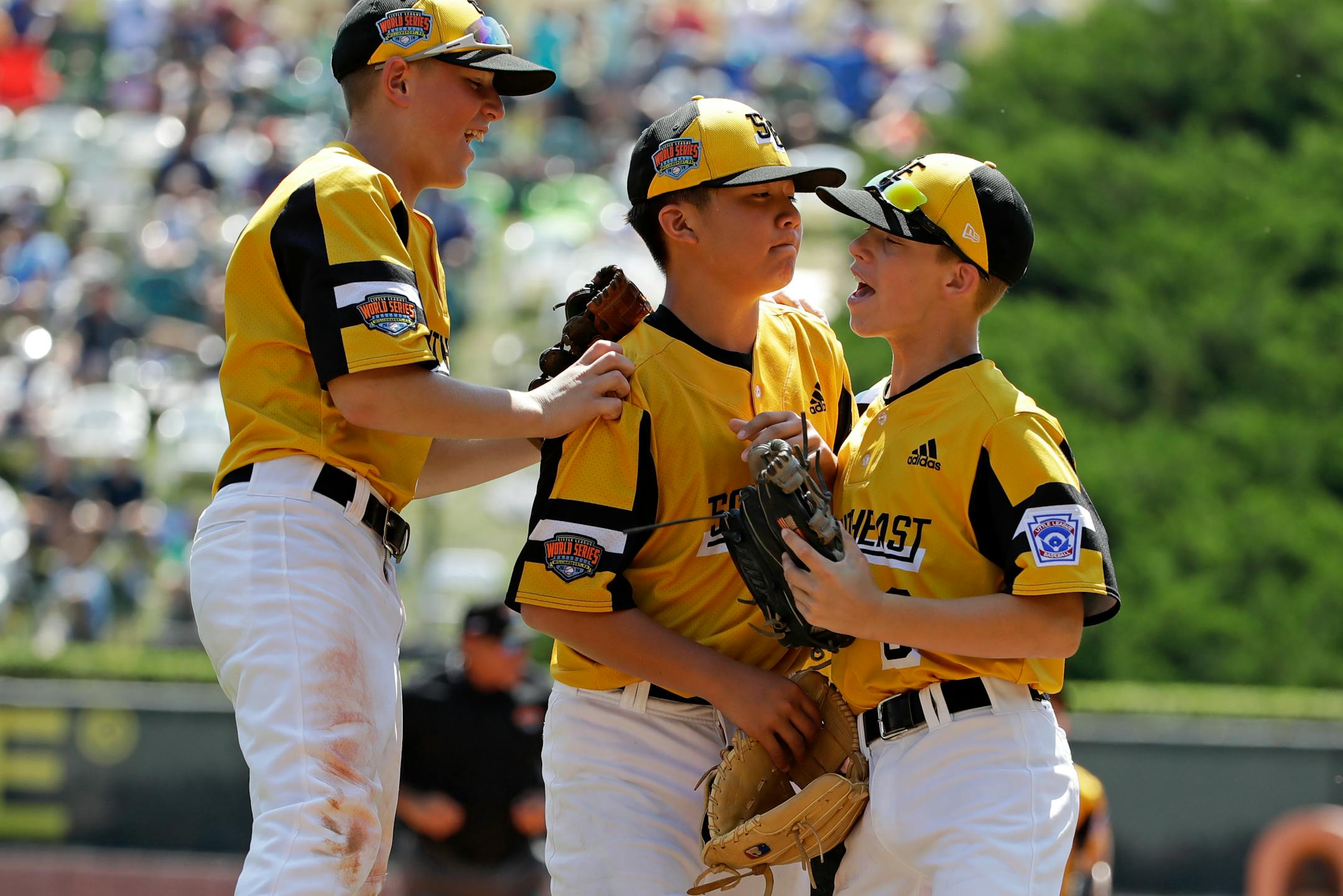 South Riding, Virginia pitcher Justin Lee, center, celebrates as he walks off the field with Chase Obstgarten, left, and Colton Hicks (9) after getting the final out of the fourth inning and an 11-0 win over Coon Rapids, Minnesota in a baseball game at the Little League World Series tournament in South Williamsport, Pa., Sunday, Aug. 18, 2019. Lee allowed no hits in the contest. (AP Photo/Gene J. Puskar)