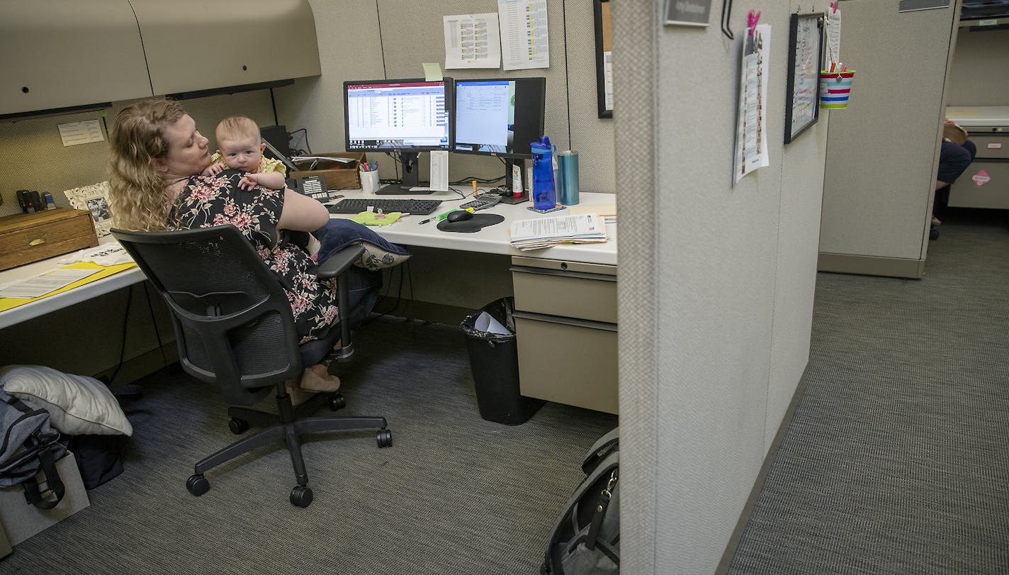 Amy Deutschman, worked at her cubicle with her infant daughter Noelle in hand, at an early education nonprofit Think Small, Wednesday, June 26, 2019 in St. Paul, MN. The nonprofit company started an "infants in the workplace" policy that allows new moms and dads bring their baby to work up until the infant turns 3 months old. ] ELIZABETH FLORES &#x2022; liz.flores@startribune.com