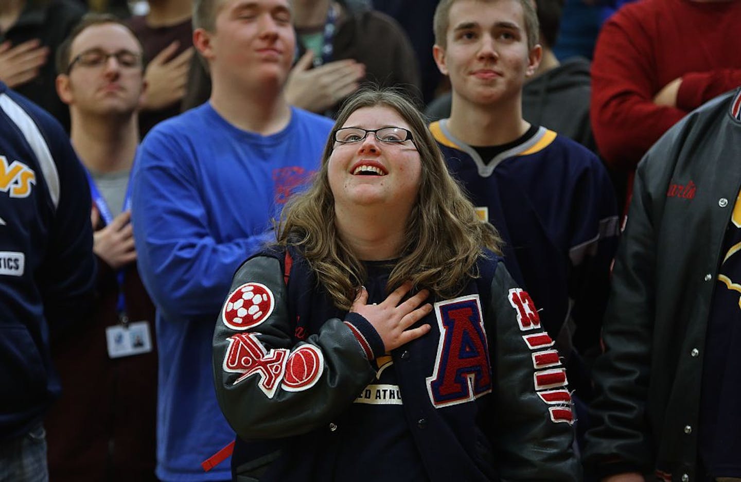 Senior Bailey Miller proudly stood at attention with her teammates and other classmates during the playing of the National Anthem at a pep rally at Robbinsdale Armstrong High School. Miller was a member of the school's adapted soccer team which won a state title. The team was recognized for their achievement during the rally. Behind Miller were teammates Mike Madson (middle left) and Tyler Sarff (middle right).