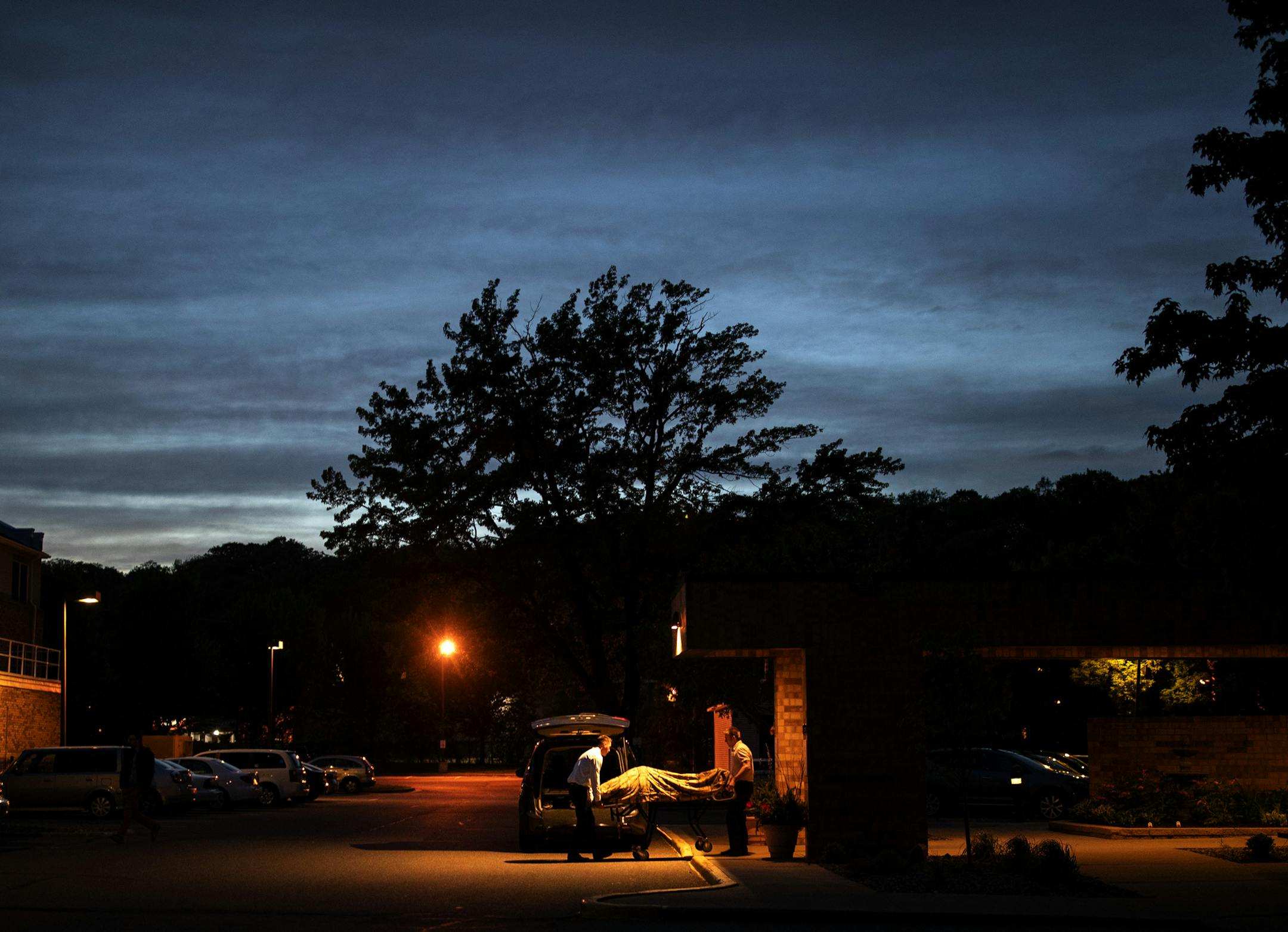 Funeral directors Aaron Stromberg helped Verlin Stoll remove a body on a stretcher from an apartment complex. Stromberg was assisting Stoll on this call.