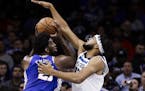 Philadelphia 76ers' Joel Embiid, left, looks for a shot as Minnesota Timberwolves' Karl-Anthony Towns defends during the first half of an NBA basketba