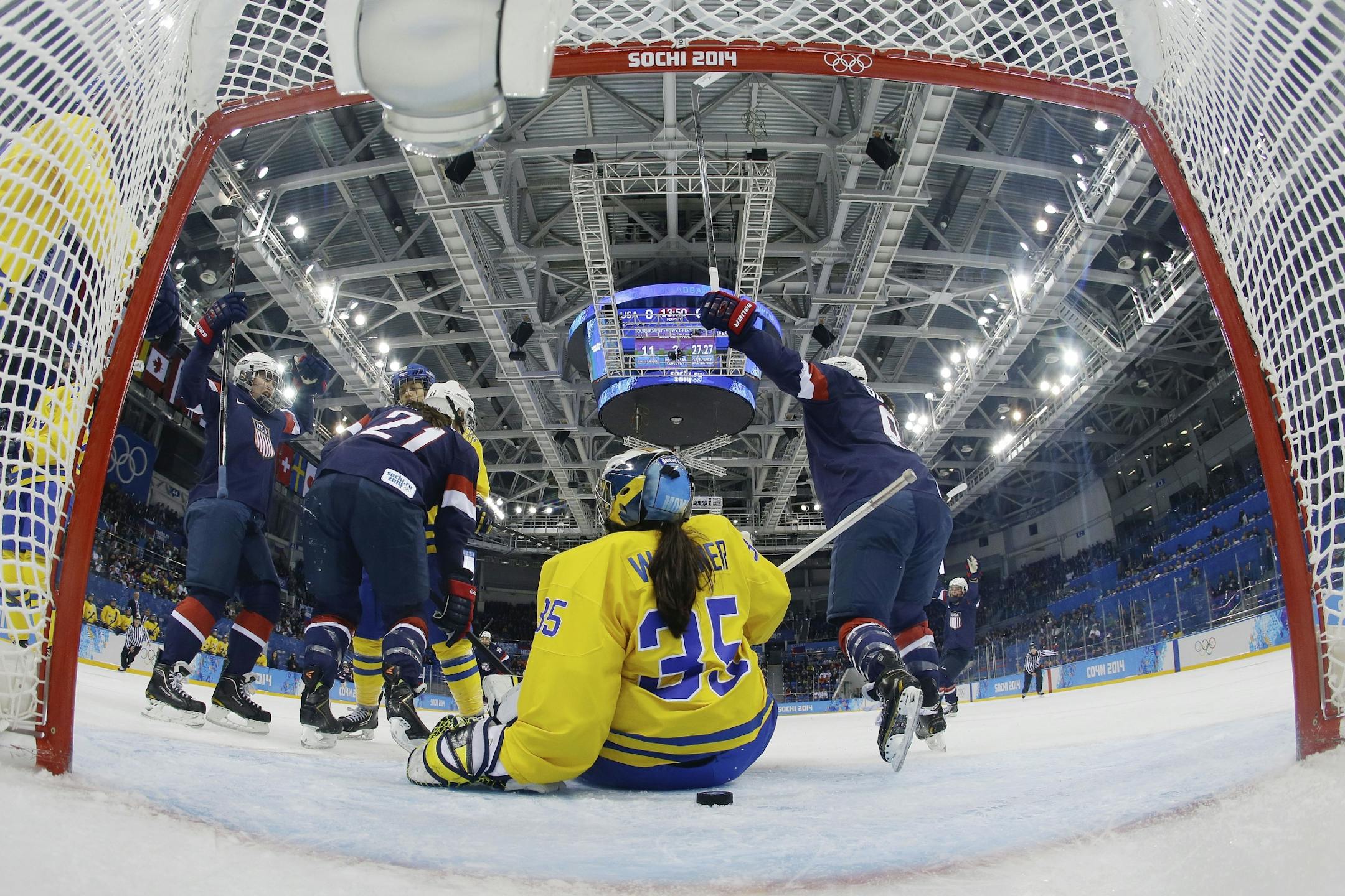 Team USA celebrates Alex Carpenter's goal as Goalkeeper Valentina Wallner of Sweden sits on the ice during the first period of the 2014 Winter Olympics women's semifinal ice hockey game at Shayba Arena, Monday, Feb. 17, 2014, in Sochi, Russia.