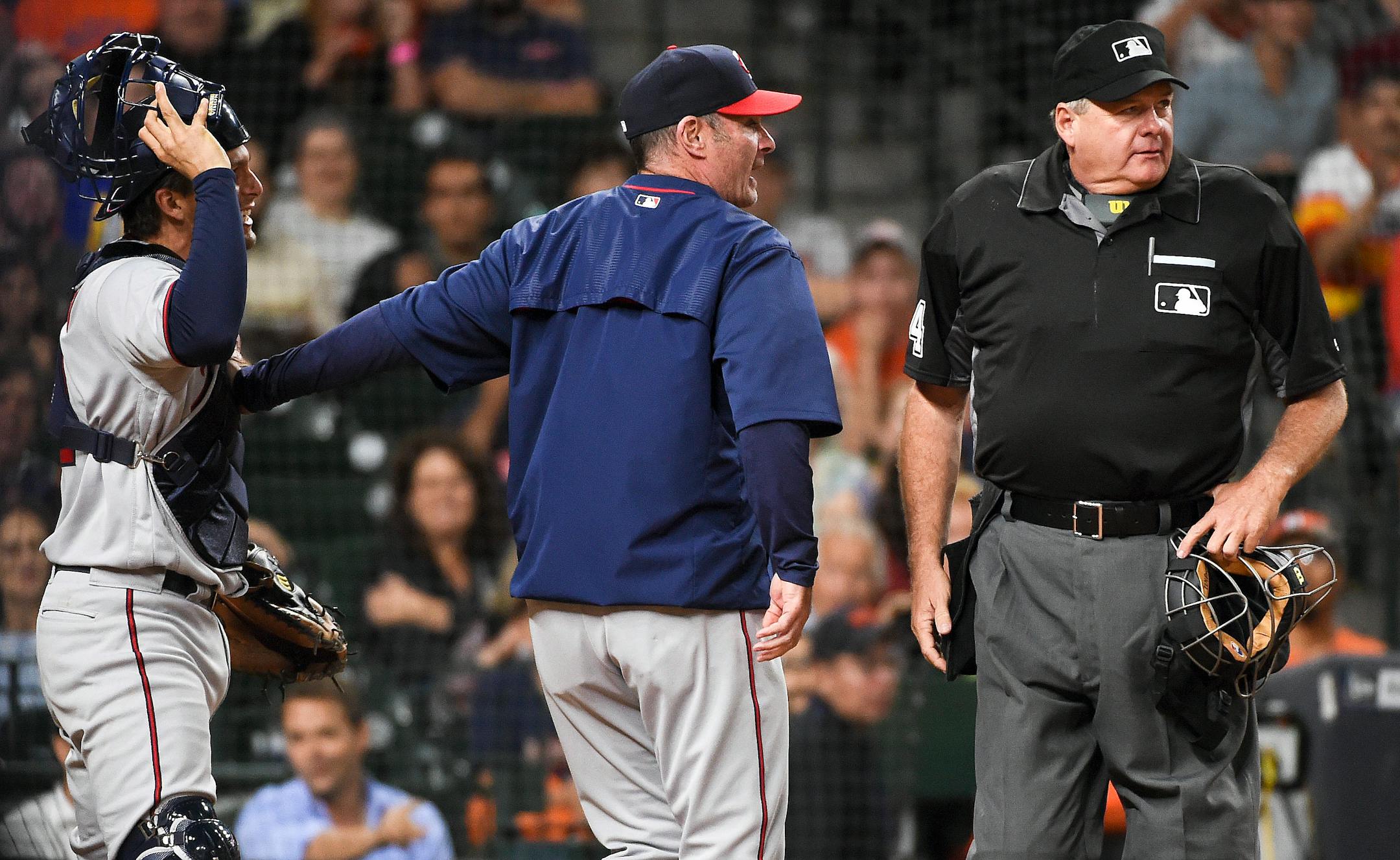 Minnesota Twins manager Paul Molitor, center, holds back catcher John Ryan Murphy, left, after home plate umpire Jerry Lane, right, threw out Murphy in the fifth inning of a baseball game against the Houston Astros, Monday, May 2, 2016, in Houston. (AP Photo/Eric Christian Smith) ORG XMIT: MIN2016050221411393