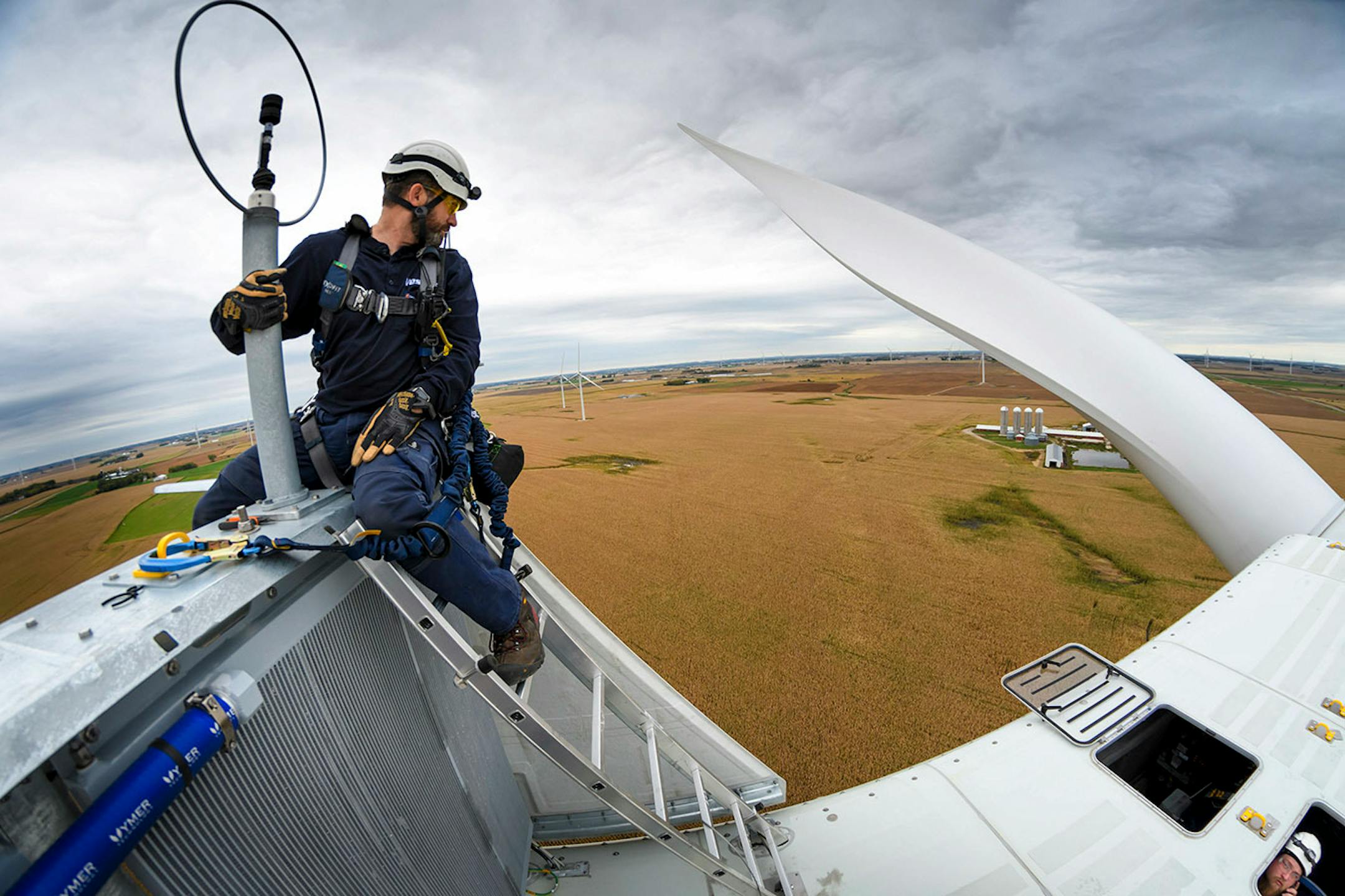 Outside the nacelle of a Vestas wind turbine, Will Osborn, left and Chris Berg talked over the servicing of a wind sensor that was out of alignment.