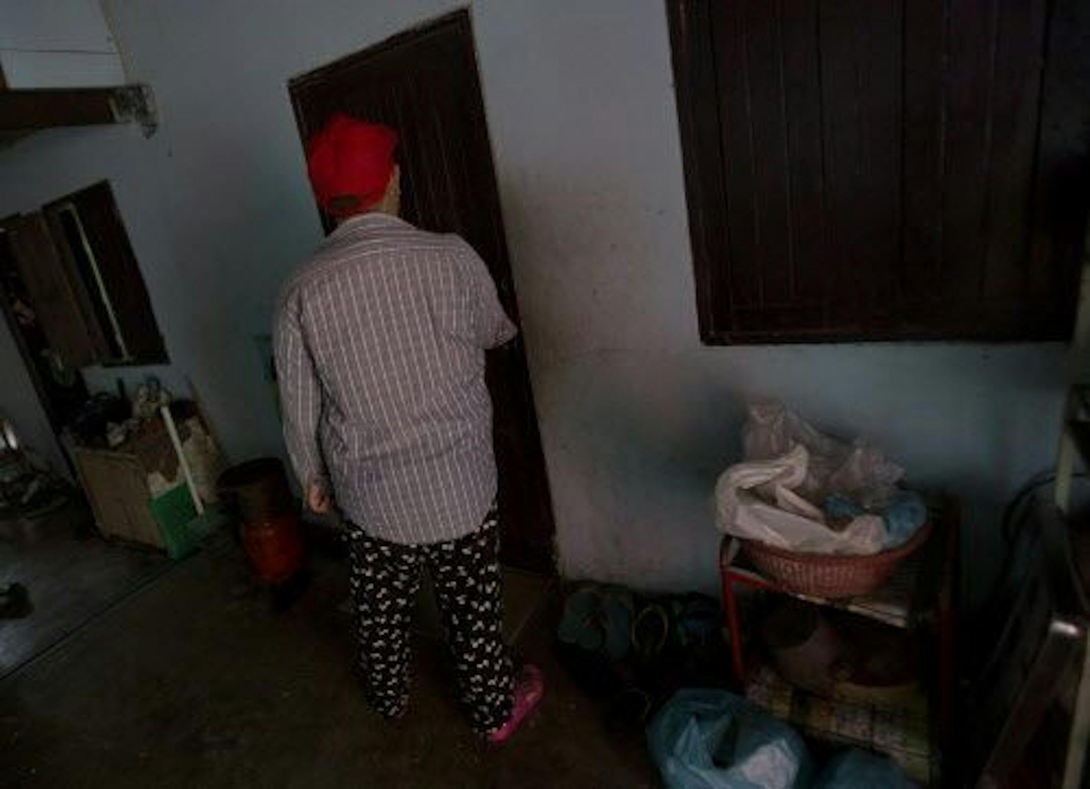 In this Friday, Aug. 29, 2014 photo, Wassana stands in front of a rented room in Bangkok,Thailand.