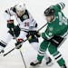 Minnesota Wild defenseman Nick Seeler (36) and Dallas Stars defenseman Jamie Oleksiak (2) skate for control of the puck during the first period of an 