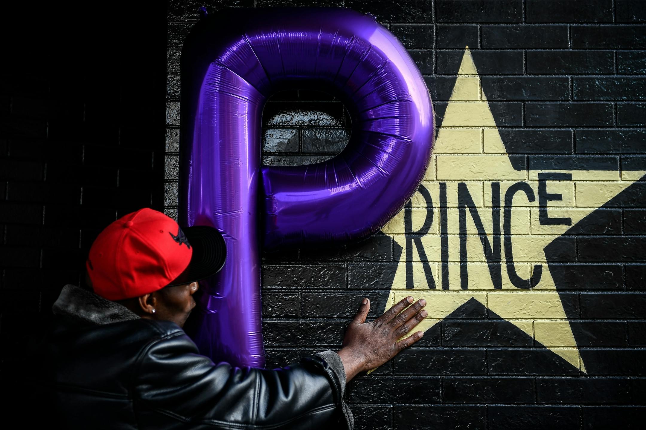 Shannon Nelson, of St. Paul, touched the Prince star on the side of First Avenue as he kissed a balloon Friday afternoon. Nelson says he's a distant relative of Prince.