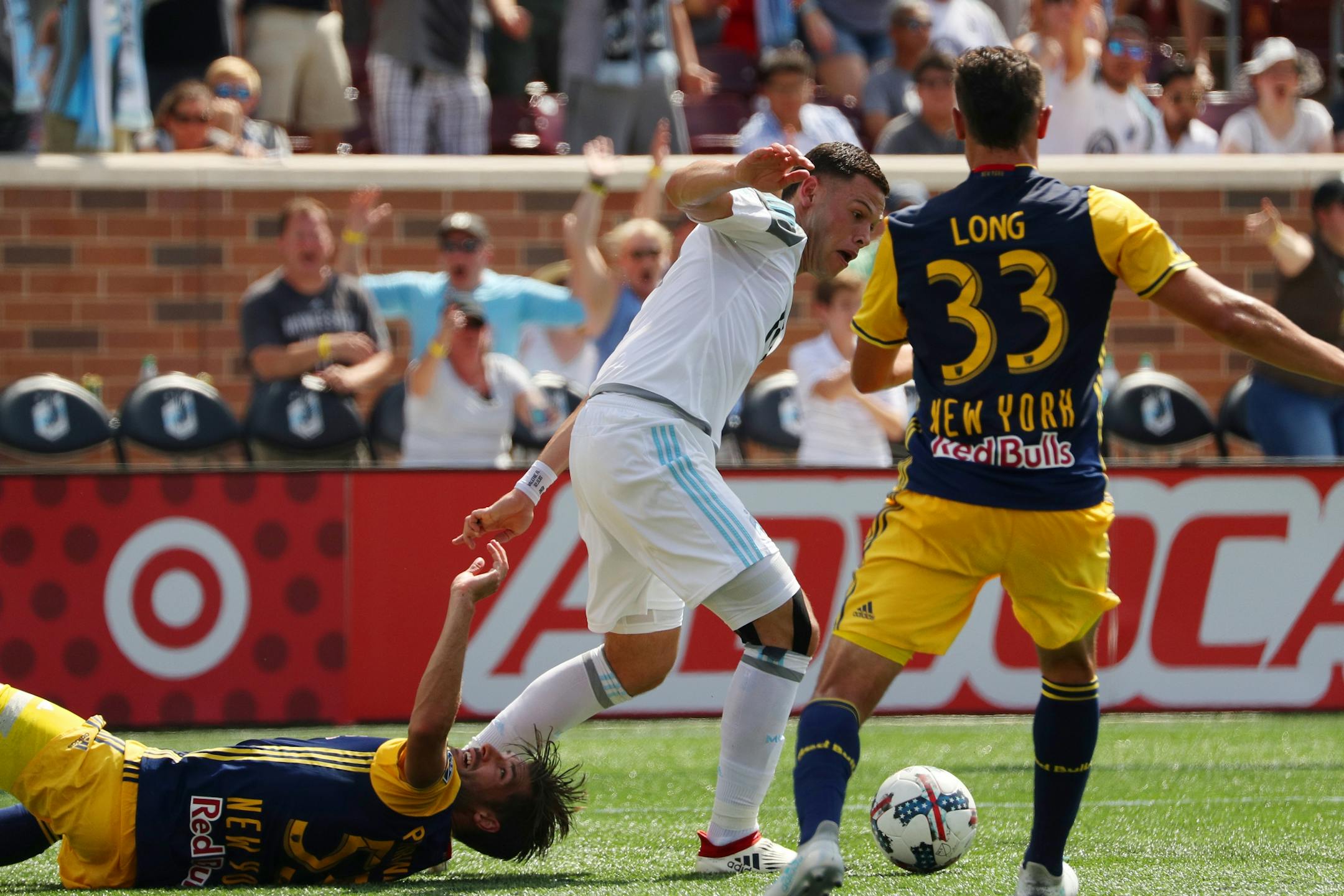 Minnesota United forward Christian Ramirez (21) got tangled up with New York Red Bulls defender Damien Perrinelle (55) as he tried to pass the ball past New York Red Bulls midfielder Aaron Long (33) in the first half.