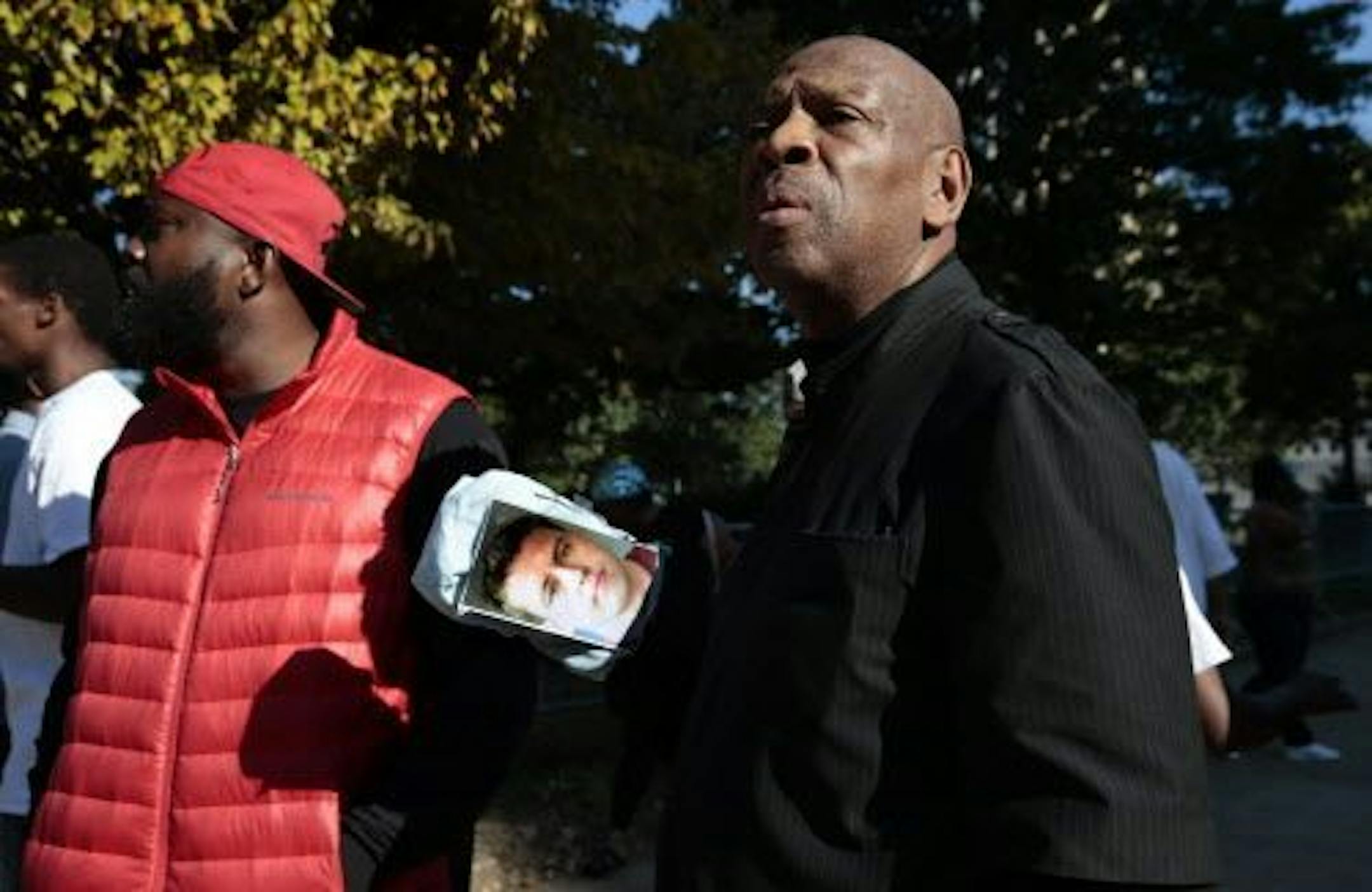 Anthony Shahid holds a photo of former St. Louis police officer Jason Stockley, as he stands with Michael Brown, Sr., father of Michael Brown, as they rally in opposition to a not guilty verdict of Stockley on Friday, Sept. 15, 2017 in St. Louis. A judge acquitted a Stockley in the death of 24-year-old Anthony Lamar Smith, who was fatally shot following a high-speed chase in 2011.