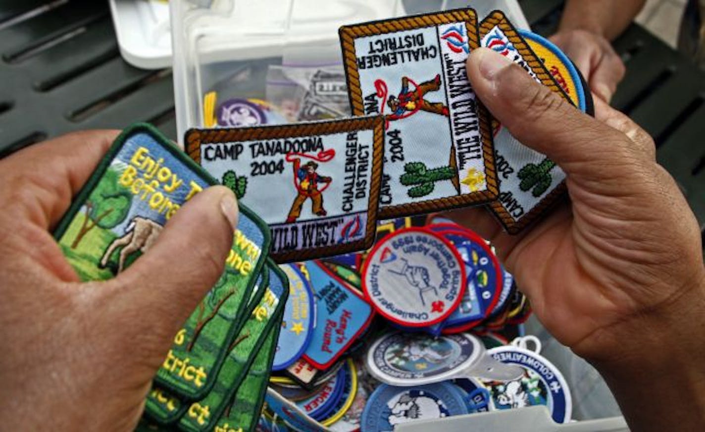 Taimi Herron showed badges and camp patches to the troop, including her son Shawn, left.