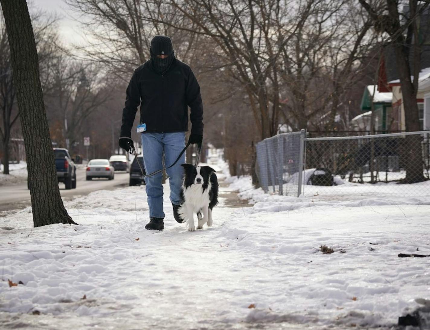 David Pogorilich and his border collie Odin walked along an icy sidewalk on Lyndale Avenue North in Minneapolis. Pogorilich, who moved from Florida in October, said he received a list of responsibilities from the city upon arriving, which included garbage pickup information, and removing snow from the sidewalks.