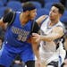 Dallas Mavericks' Seth Curry, left, keeps the ball at a safe distance from Minnesota Timberwolves' Ricky Rubio, of Spain, during the first half of an 