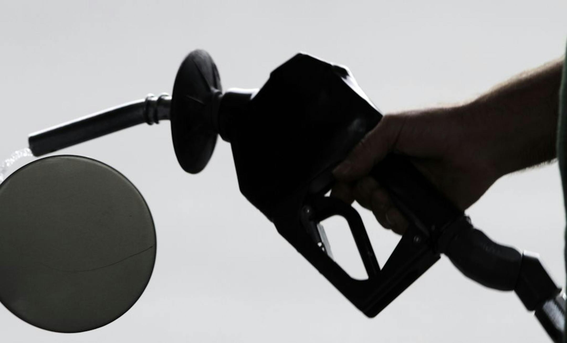 In this Aug. 15, 2011 photo, a motorist pulls the nozzle out of his gas tank after fueling his car at a station in Augusta, Maine. For the first time in months, retail gasoline prices have fallen below $3 a gallon in places, including parts of Michigan, Missouri and Texas. And the relief is likely to spread thanks to a sharp decline in crude-oil prices.