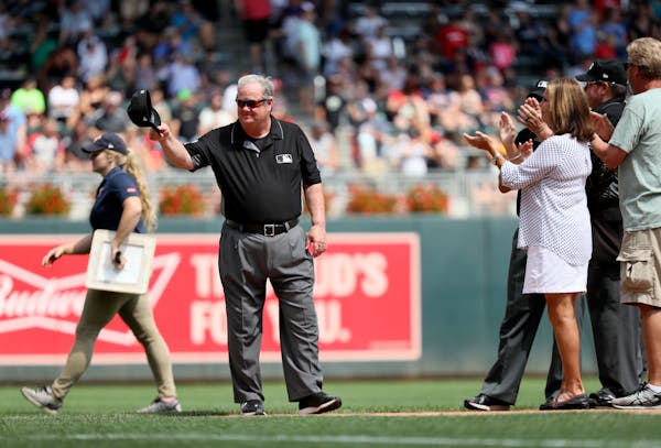 Major League umpire Joe West tips his cap after he was recognized for umpiring the second most major league games