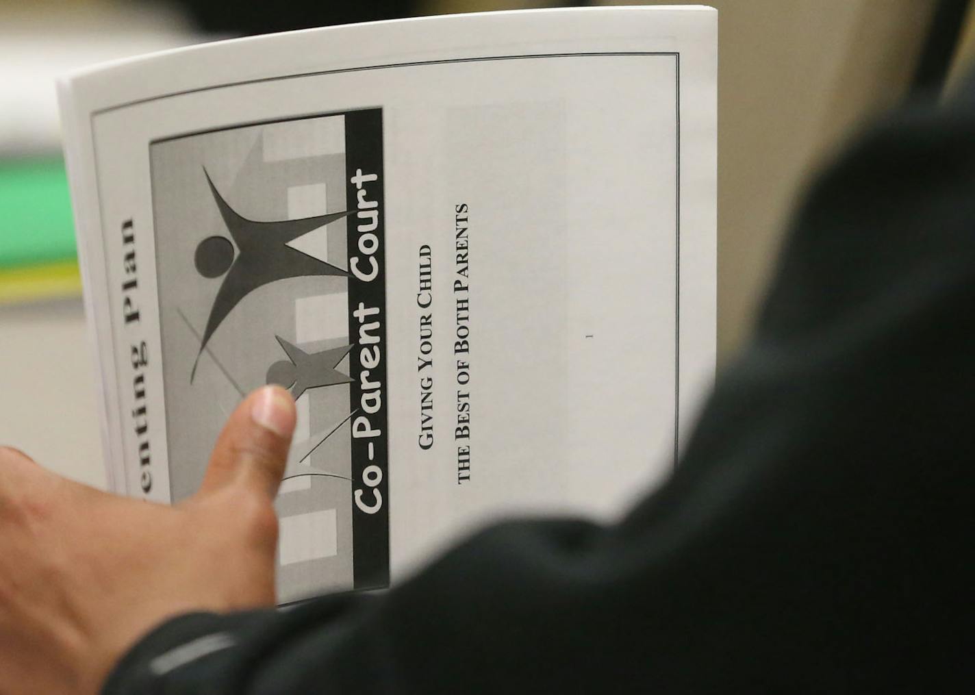 One of the fathers held a handout as he listened to the discussion during the fourth of a series of co-parenting classes sponsored in part by Hennepin County in Minneapolis Tuesday, December 10, 2013 ] (KYNDELL HARKNESS/STAR TRIBUNE) kyndell.harkness@startribune.com