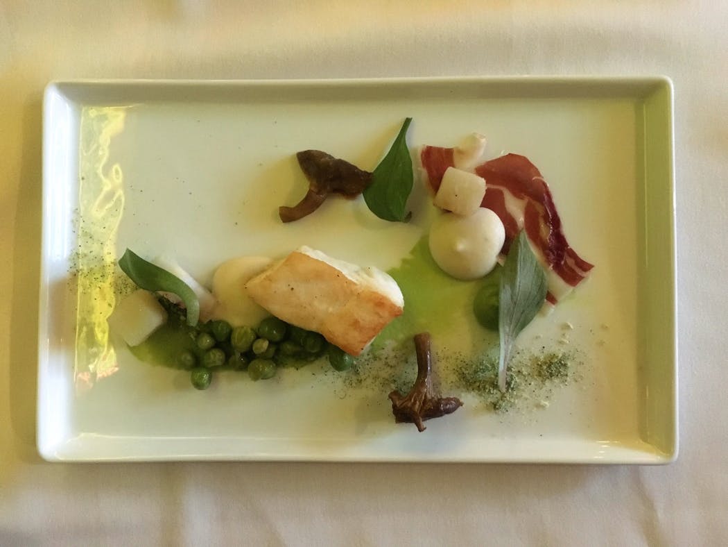 One course in Travail's Homage tasting menu features halibut, ham and peas.