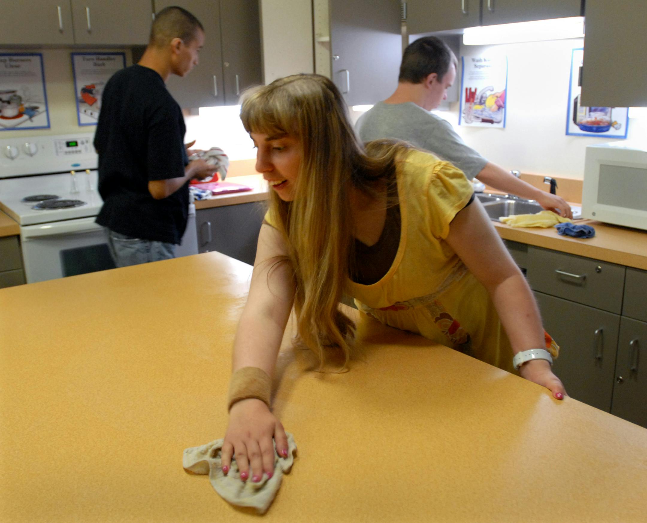 Kaylie Huxtable cleaned off the table as (left to right) Jeff Sandhofer and Jake Brown cleaned up dishes from the class project of preparing strawberry pineapple cups. The students were in their apartment living class at South Education Center, a new school to teach disabled students how to function in everyday life. Huxtable is 19 years old and from Elko. Brown is 20 and from Bloomington and Sandhofer is 21 and from Edina.
