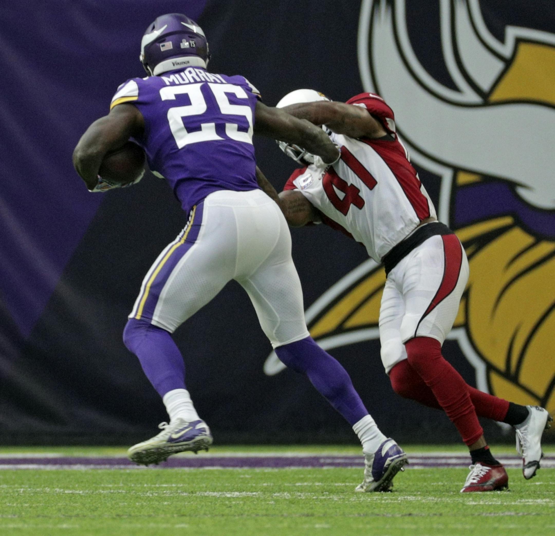 Vikings Latavius Murray stiff-arms Arizona's Antoine Bethea on his way to a 21 yard TD run in the 1st quarter.