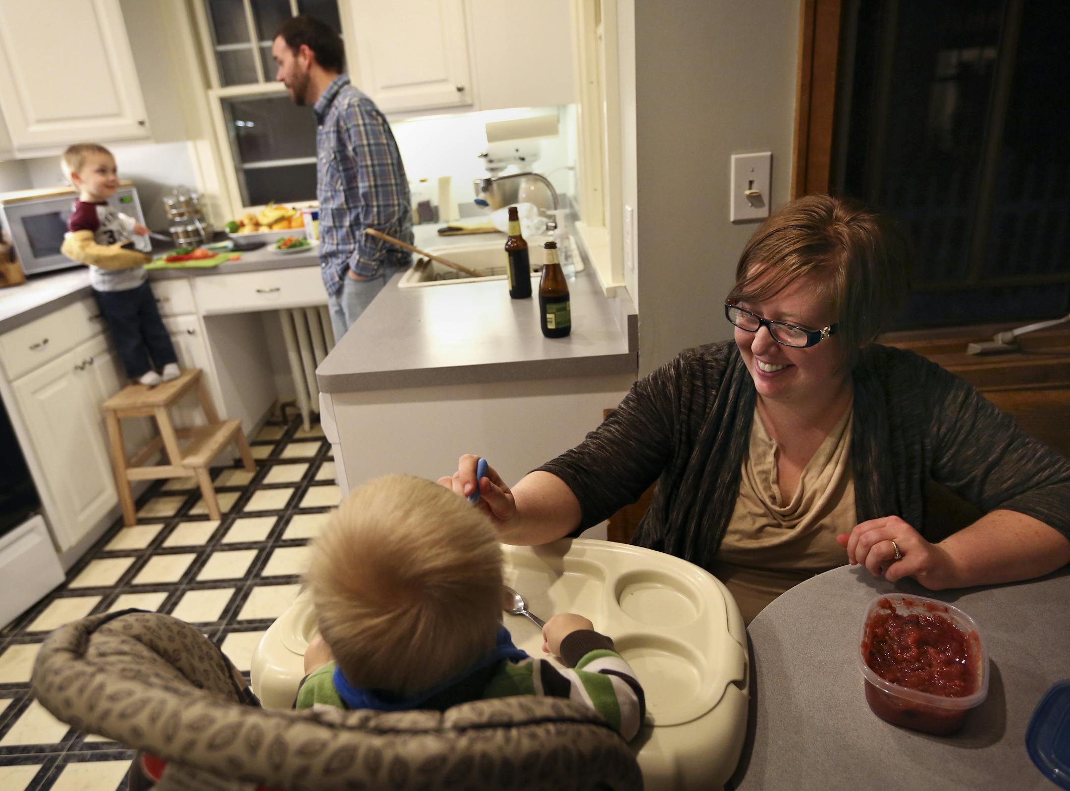 Jaci Schloesser fed her son Owen, 1, as her husband Scott made pizza with their other son Ben, 2, for dinner at their home in St. Paul, Minn., on Friday, January 3, 2014. The family moved to the city from New Brighton last May. ] RENEE JONES SCHNEIDER &#x201a;&#xc4;&#xa2; reneejones@startribune.com ORG XMIT: MIN1401031754291138