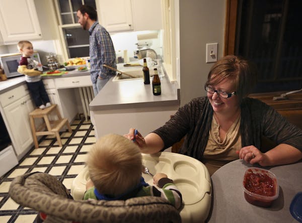 Jaci Schloesser fed her son Owen, 1, as her husband Scott made pizza with their other son Ben, 2, for dinner at their home in St. Paul, Minn., on Frid