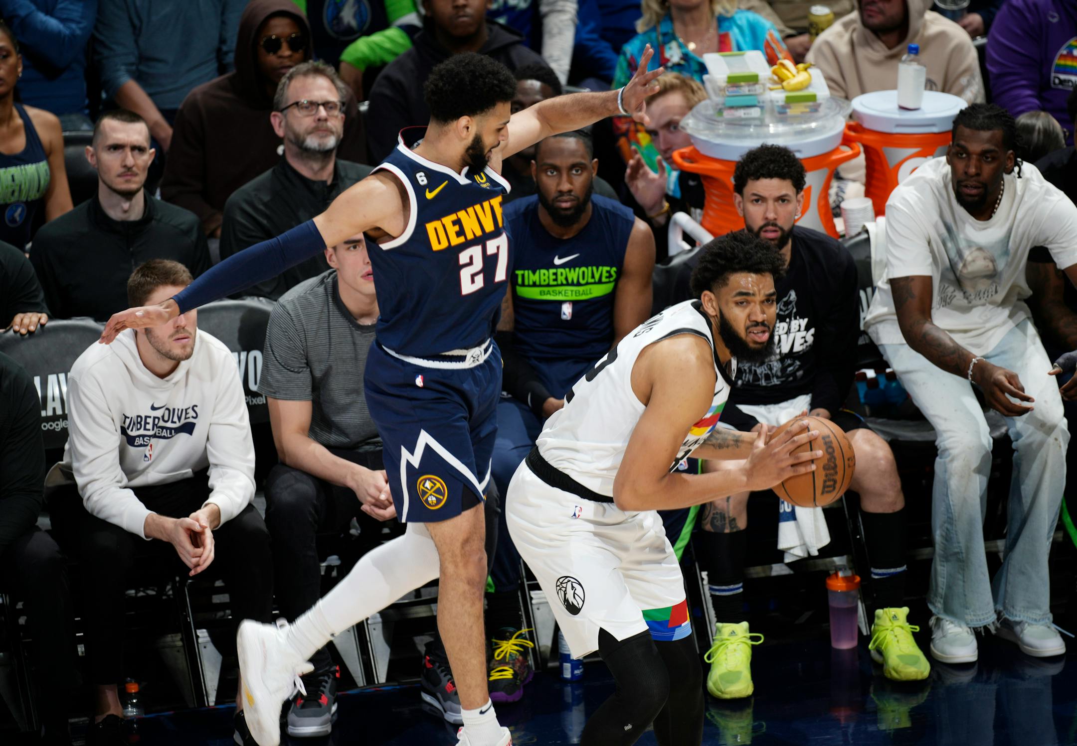 Minnesota Timberwolves center Karl-Anthony Towns, right, looks to pass the ball as Denver Nuggets guard Jamal Murray defends during the first half of Game 2.