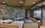 A cozy stone and timber grotto with a hot tub that can seat up to 10 people inside a 11,193 square foot Tonka Bay home for sale for $5.25 million.