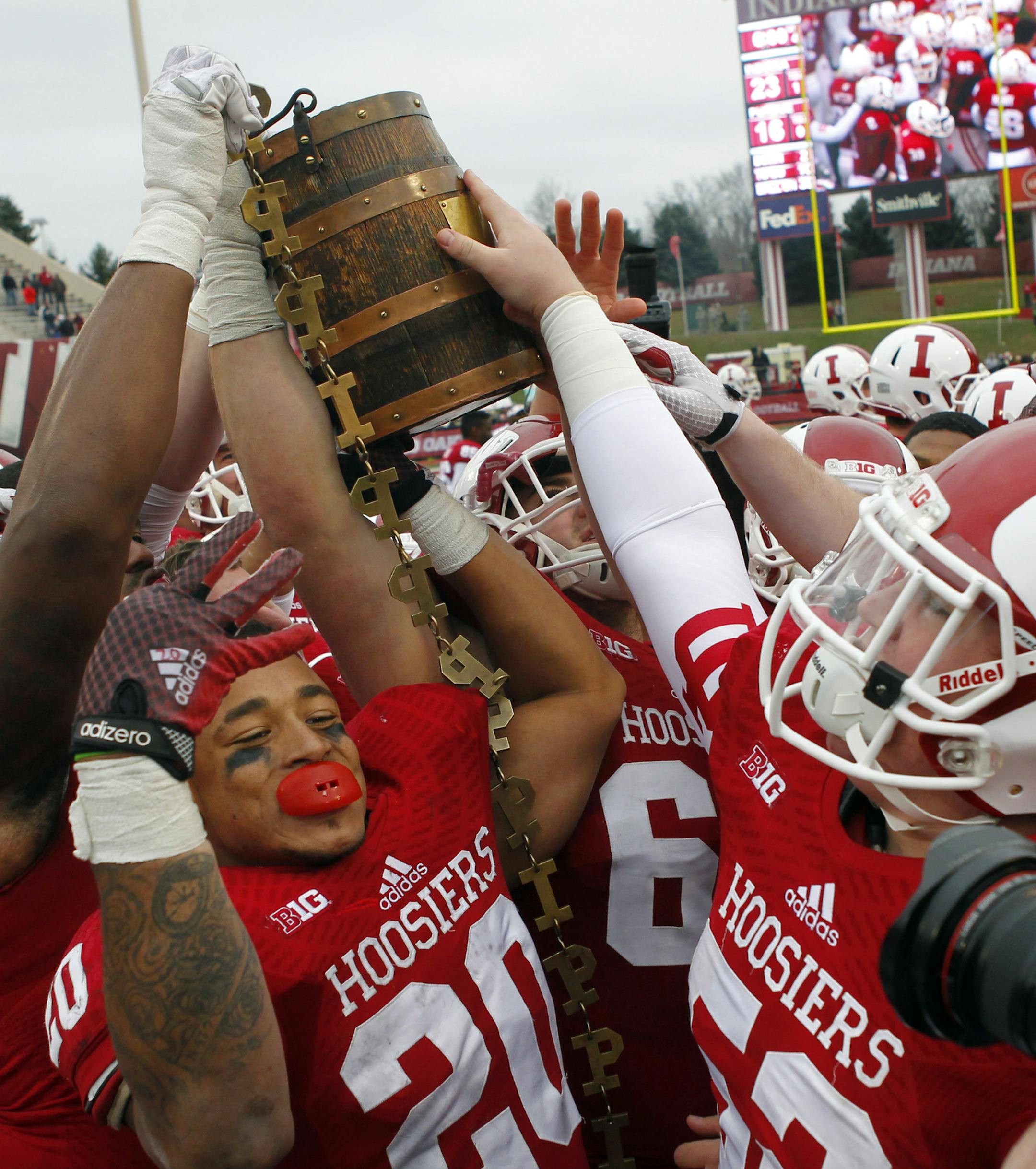 Indiana players celebrate with the Old Oaken Bucket at midfield after defeating Purdue 23-16 in an NCAA college football game at Memorial Stadium in Bloomington, Ind., Saturday, Nov. 29, 2014. (AP Photo/John Sommers II)