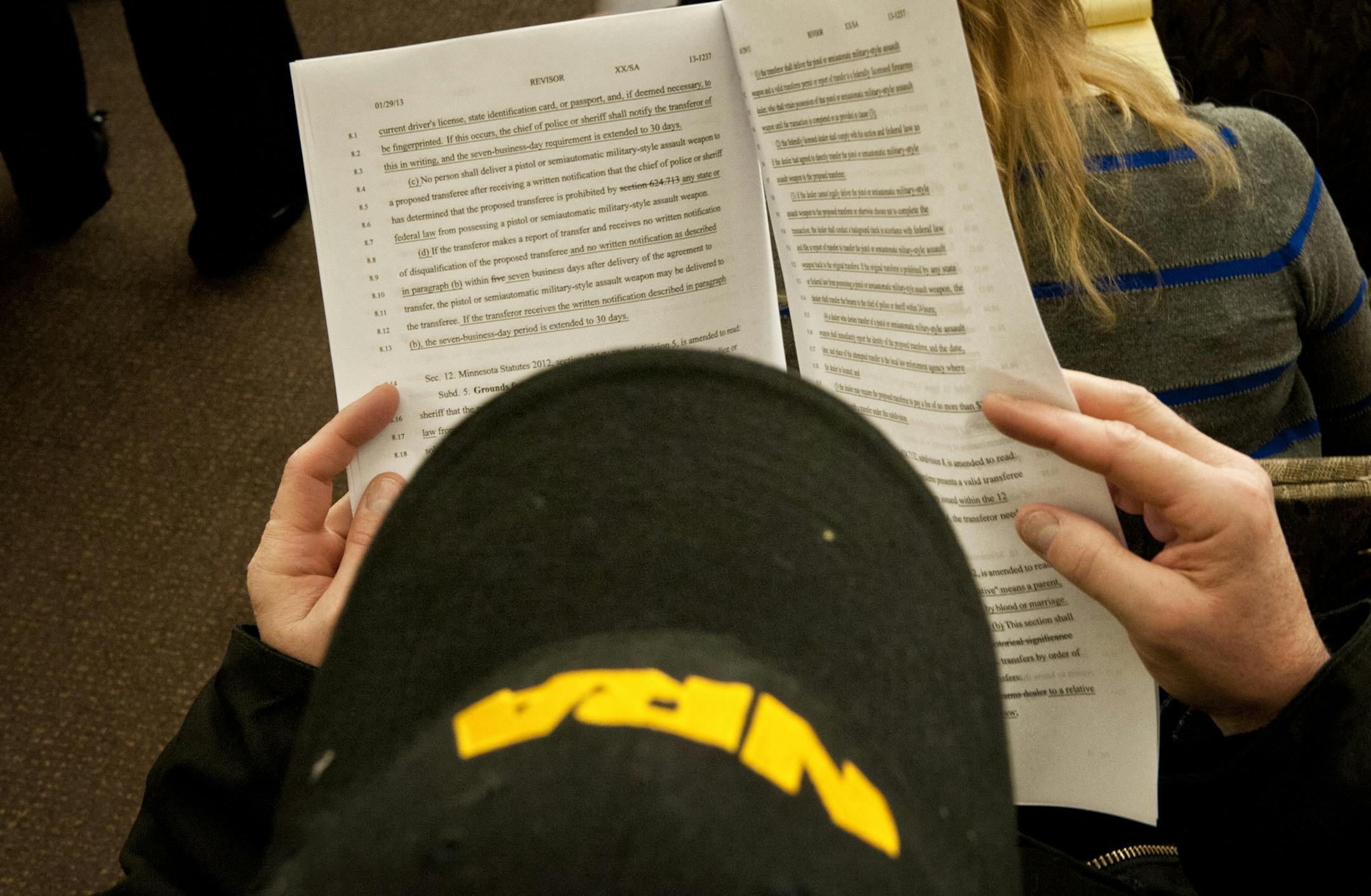 An NRA member opposed to gun regulation read through Michale Paymar's bill in the committee room. Supporters of universal background checks for guns faced a stiff test in House public safety committee Tuesday, March 19, 2013. The bill containing background checks may not have the votes, and the sponsor is seeking a last-minute compromise to keep the concept alive. ] GLEN STUBBE * gstubbe@startribune.com