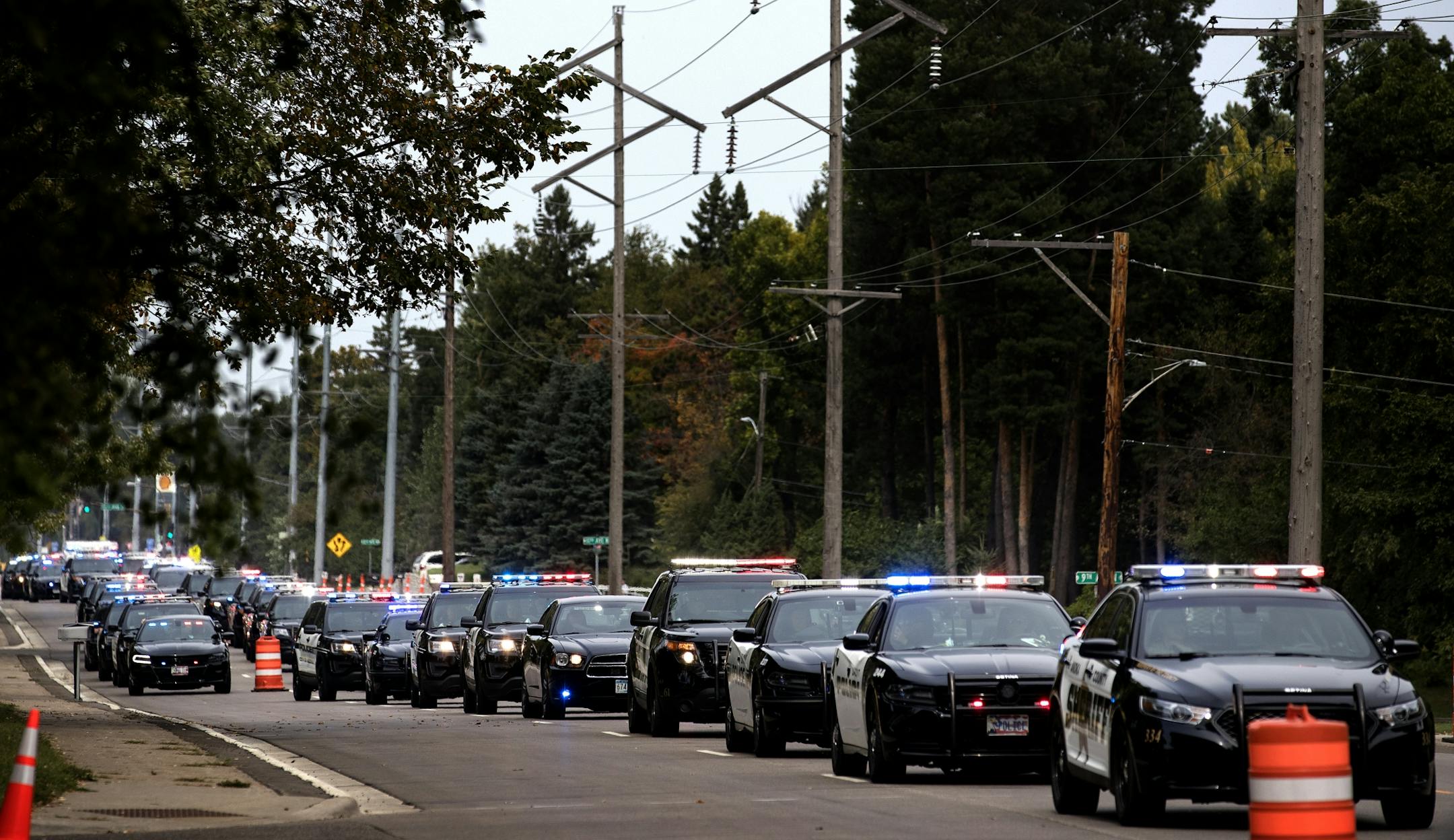 Law enforcement vehicles left the Wayzata Free Church after the funeral service for officer William Mathews.