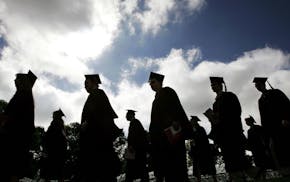 FILE - In this Friday, May 12, 2006, file photo, university students in their caps and gowns are silhouetted as they line up for graduation ceremonies