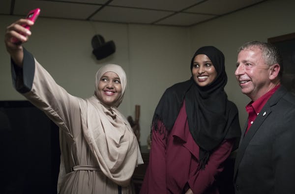 Ayan Abdi left ,and Nimo Ahmed took a photograph with St. Cloud Mayor Dave Kleis during a dinner at his home Tuesday September 19,2017 in St. Cloud, M