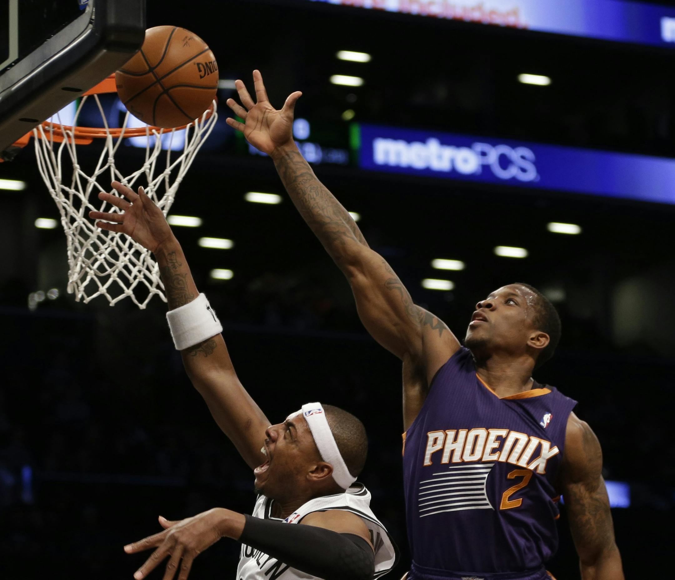 Brooklyn Nets's Paul Pierce, left, puts up a shot while Phoenix Suns' Eric Bledsoe defends during the first half of the NBA basketball game at the Barclays Center Monday, March 17, 2014 in New York. (AP Photo/Seth Wenig)