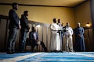 Osman Ahmed sits down due to his injuries while Alhikma Islamic Center Imam Abdirazak Kaynin speaks Friday, May 24, 2024 in Minneapolis at a news conf