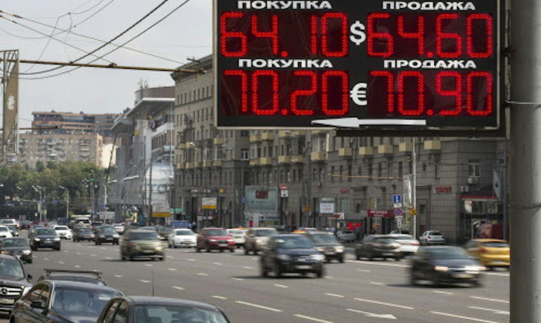Cars drive past an exchange office sign showing the currency exchange rate in Moscow, Russia, Monday, Aug. 10, 2015. Official government figures show that the Russian economy contracted 4.6 percent in the second quarter from the same quarter the previous year in the wake of plummeting oil prices and Western sanctions. (AP Photo/Alexander Zemlianichenko)
