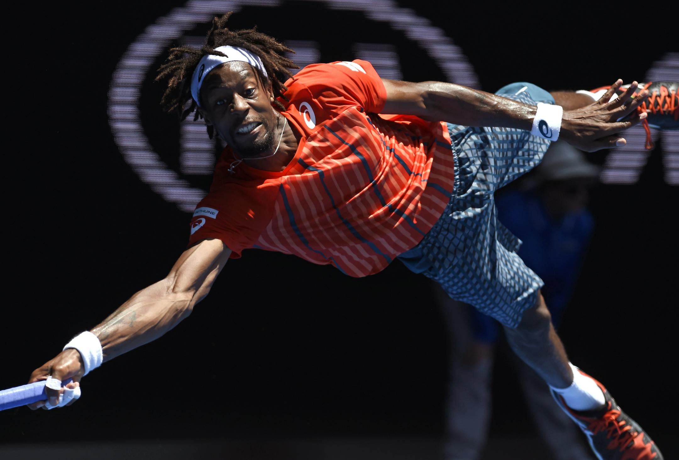 Gael Monfils of France dives to play a forehand return to Andrey Kuznetsov of Russia during their fourth round match at the Australian Open tennis championships in Melbourne, Australia, Monday, Jan. 25, 2016.(AP Photo/Andrew Brownbill)
