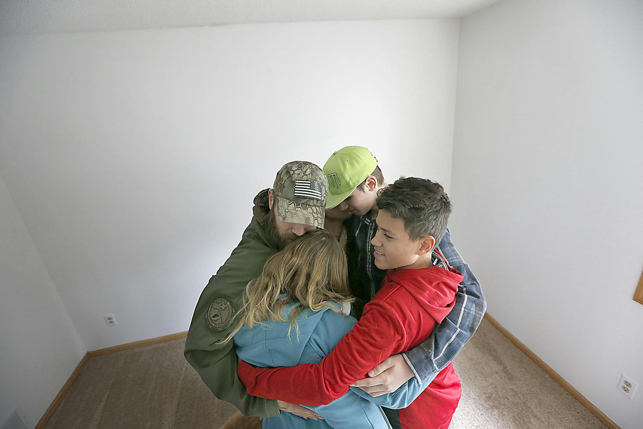 Decorated U.S. Army Veteran Reid Erickson, left, got a big hug from his family after receiving a key to his new home, Thursday, February 16, 2017 in Farmington, MN. ] ELIZABETH FLORES ï liz.flores@startribune.com