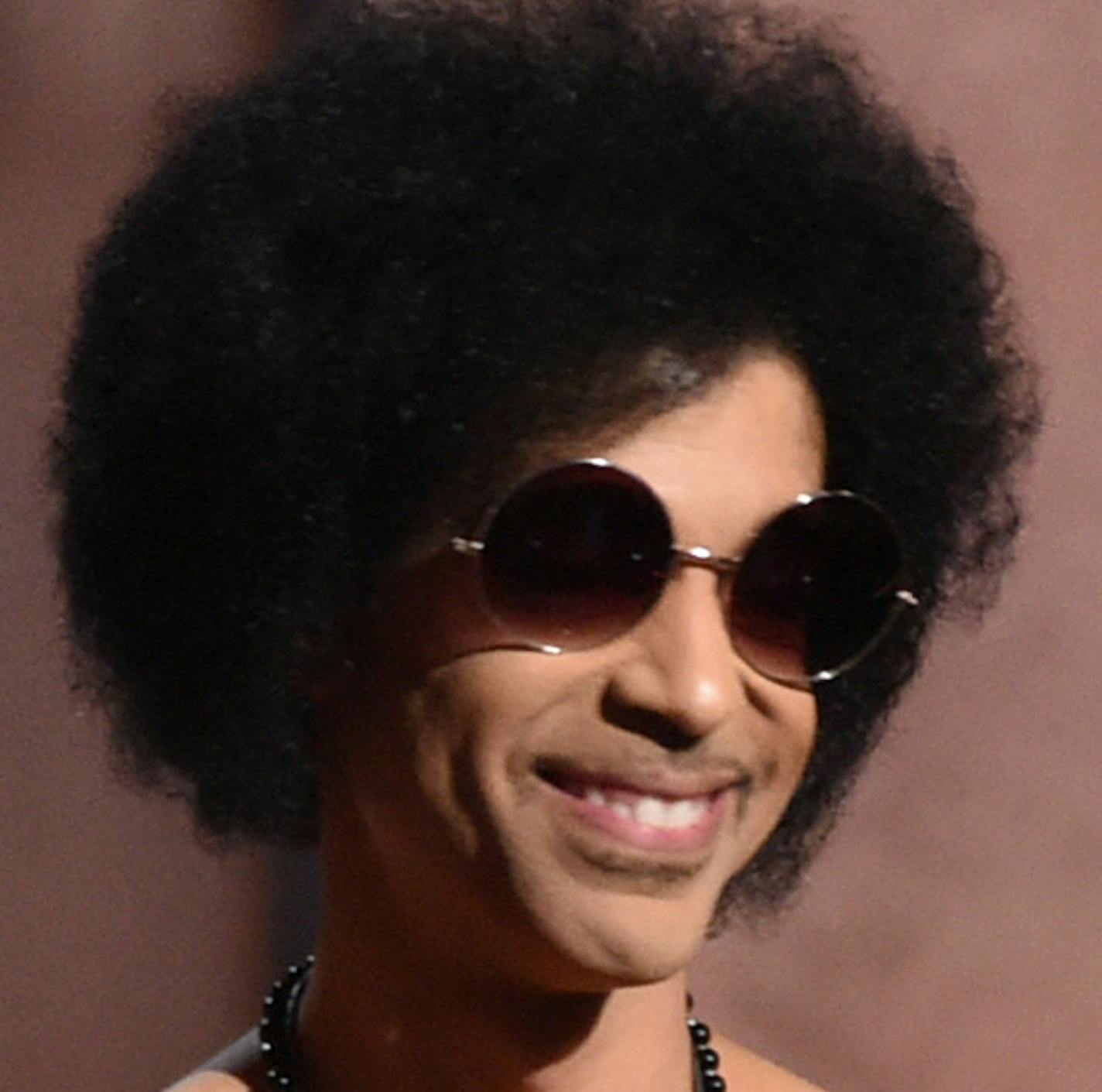 FILE - In this Feb. 8, 2015 file photo, Prince presents the award for album of the year at the 57th annual Grammy Awards in Los Angeles. Prince was the main attraction when he performed a concert early Saturday, Feb. 14, 2015 for a crowd that include Michael Jordan, Chris Rock, Questlove and Queen Latifah, who danced and sang to his rousing set in downtown New York City. (Photo by John Shearer/Invision/AP)