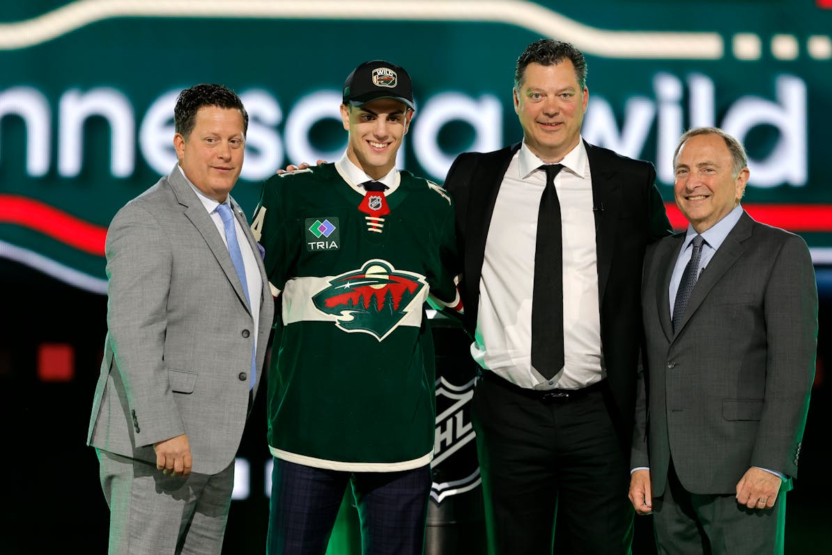 Zeev Buium, second from left, poses with, from left, Wild Director of Amateur Scouting Judd Brackett, Wild General Manager Bill Guerin and NHL Commiss