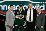Zeev Buium, second from left, poses with, from left, Wild Director of Amateur Scouting Judd Brackett, Wild General Manager Bill Guerin and NHL Commiss