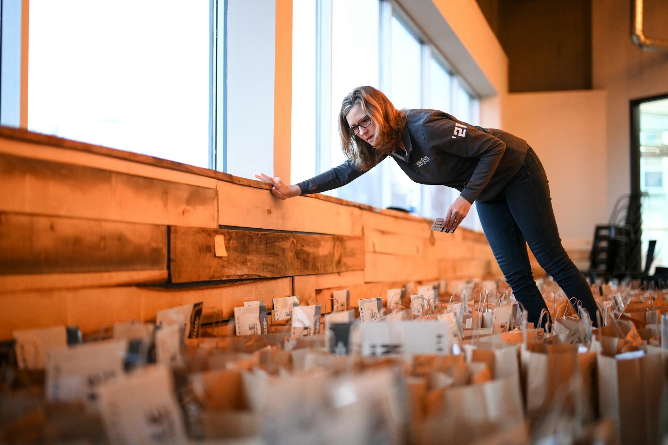Stephanie Luoma, who invested in Nine Mile Brewing with her husband Tom, prepared gift bags for the brewery's founders club Wednesday, Feb. 9, 2022 in the event space of Nine Mile Brewing in Bloomington, Minn.