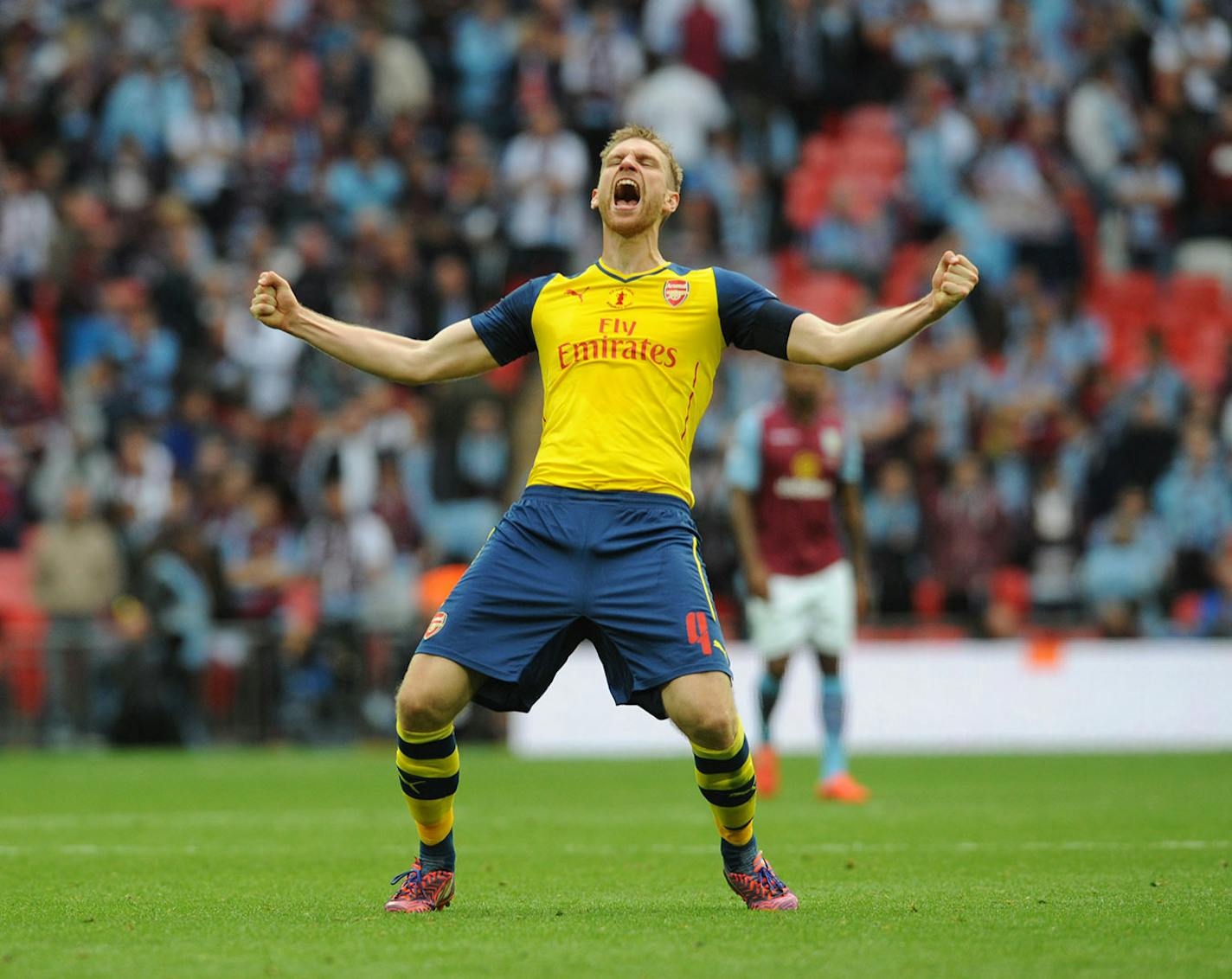 Arsenal's Per Mertesacker celebrates after his team won the English FA Cup final soccer match between Aston Villa and Arsenal at Wembley stadium in London, Saturday, May 30, 2015. Arsenal won the match 4-0.