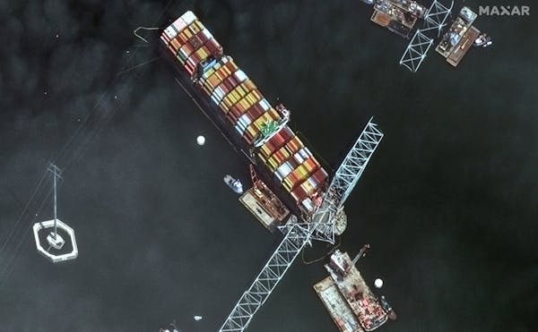 This satellite image provided by Maxar shows the bow of the container ship Dali remains stuck underneath sections of the fallen Francis Scott Key Brid