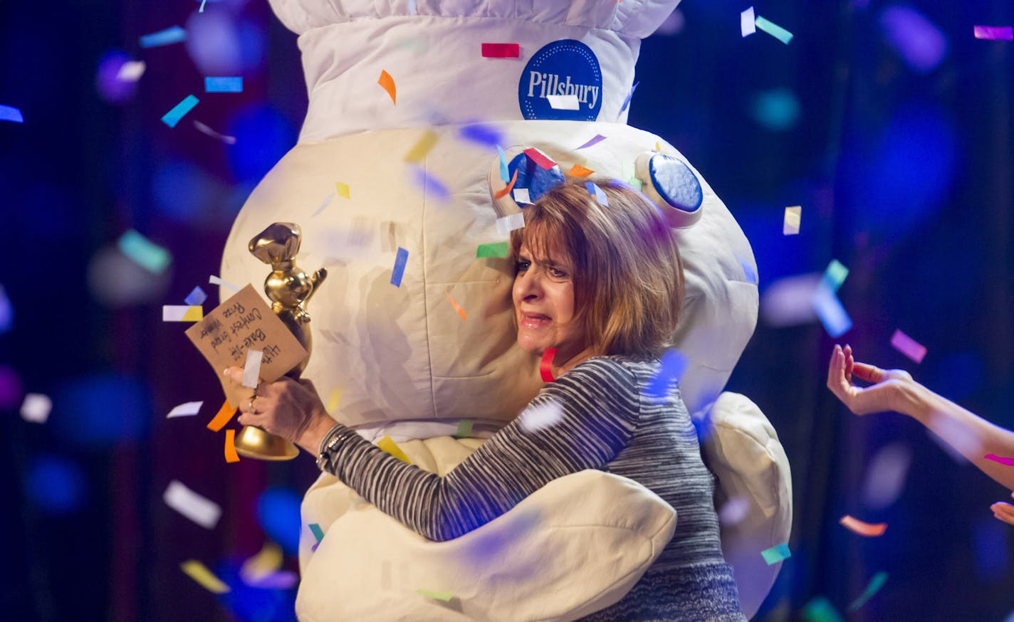 In this photo provided by Pillsbury/General Mills, Glori Spriggs hugs the Pillsbury Doughboy after winning the $1 million grand prize for her original recipe, "Loaded Potato Pinwheels," at the 46th Pillsbury Bake-Off Contest Monday, Nov. 11, 2013, in Las Vegas. She will appear on "The Queen Latifah Show" on Nov. 14, 2013. (AP Photo/Pillsbury/General Mills, Paul Morse)