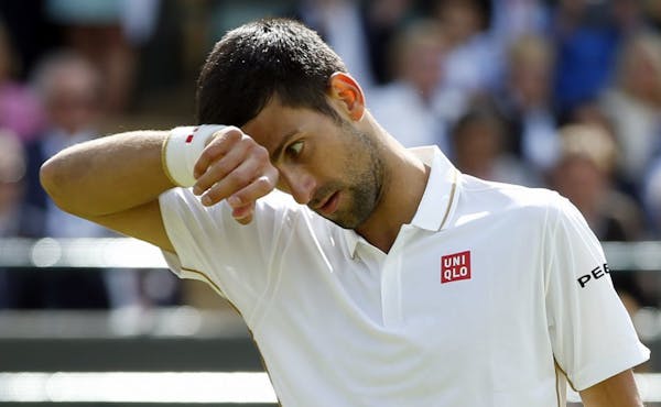 Novak Djokovic of Serbia wipes his face during his men's singles match against Sam Querrey of the U.S on day six of the Wimbledon Tennis Championships