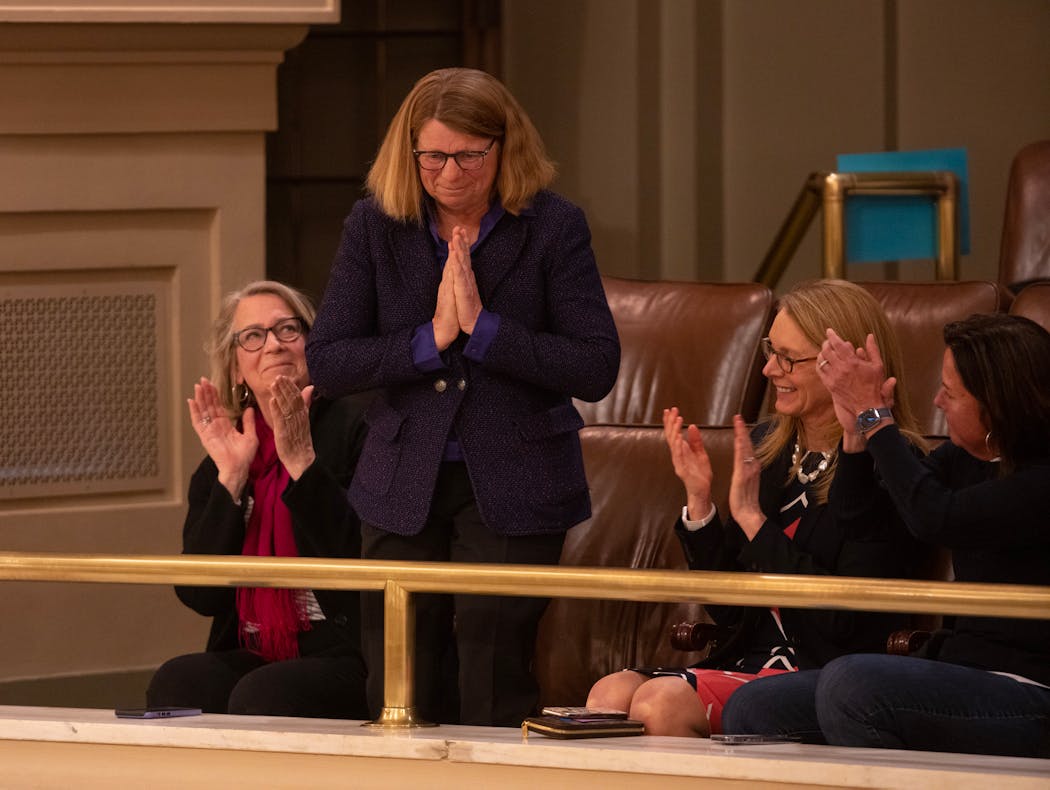 Penny Wheeler stood to acknowledge the applause after lawmakers selected her to serve as a University of Minnesota regent. Seated with her were her sister, Sue Wheeler, left, and friends Christine Moore, and Shari Ballard, right.