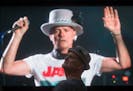 Lead singer Gord Downie is seen performing on a screen as a man watches during a viewing party for the final stop in Kingston, Ontario, from Vancouver